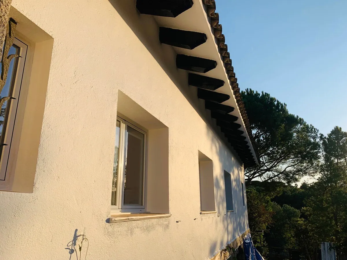 El alero y las ventanas de la casa a última hora de la tarde