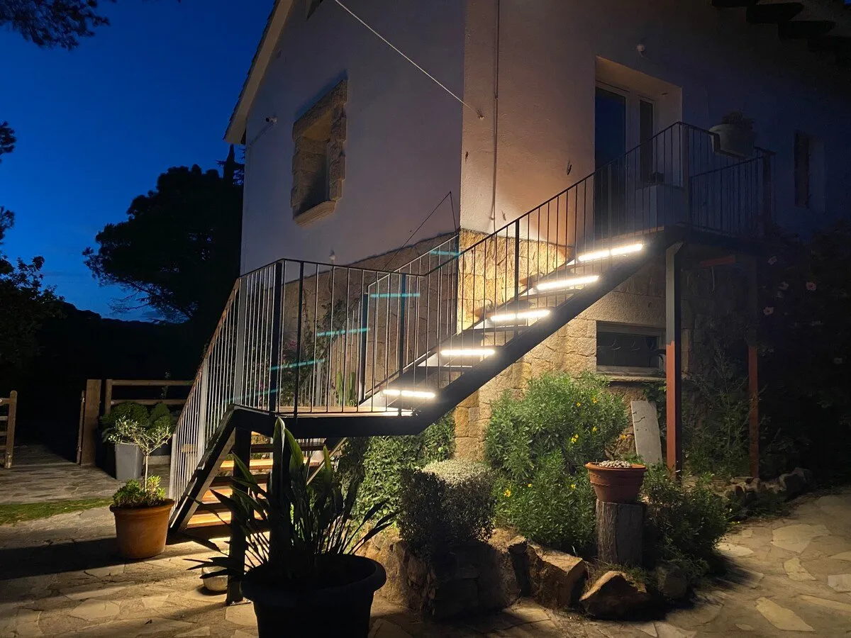 La escalera de la entrada iluminada al caer la noche