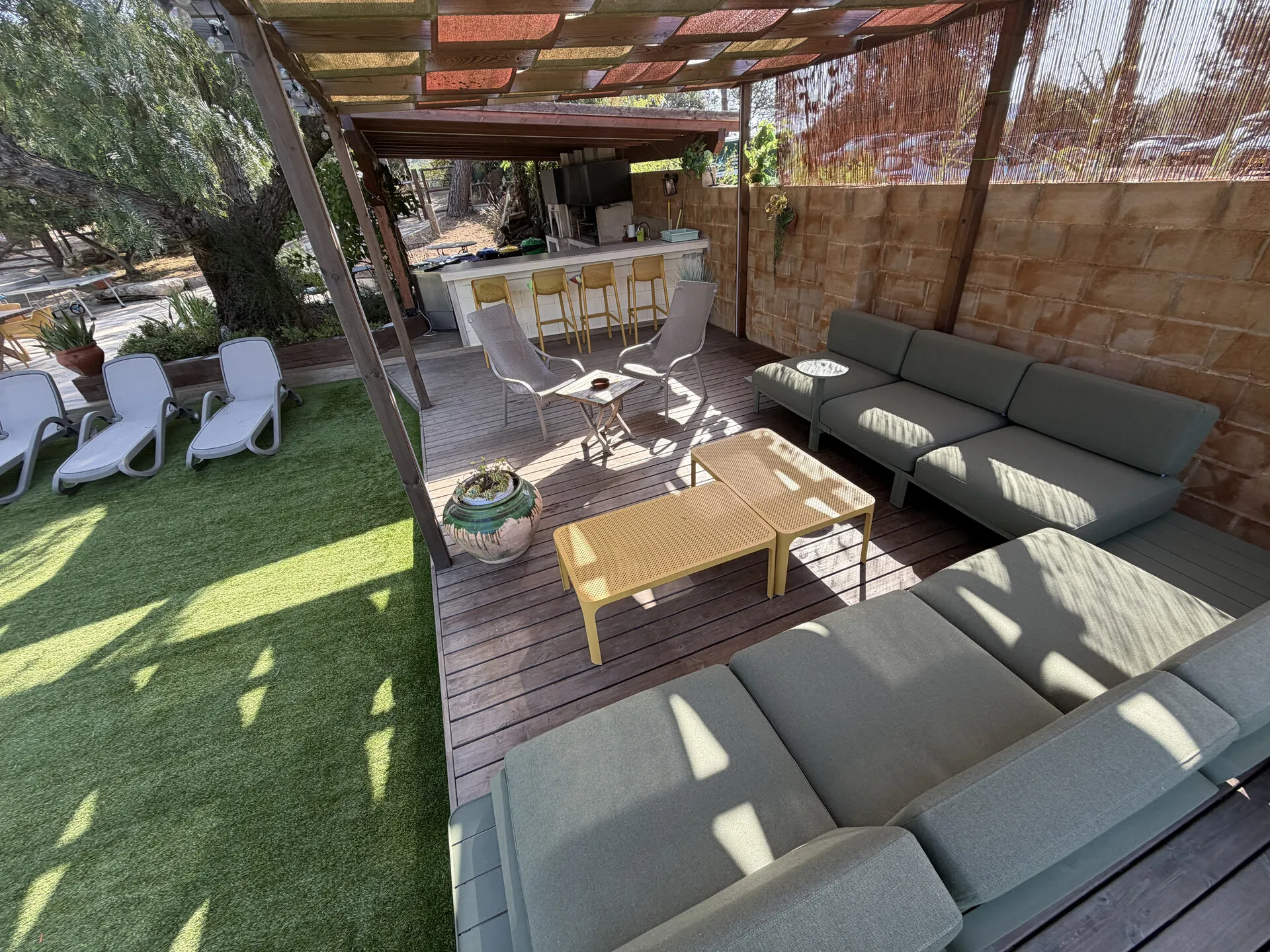 El chillout bajo la pérgola, con las tumbonas y la mesa baja