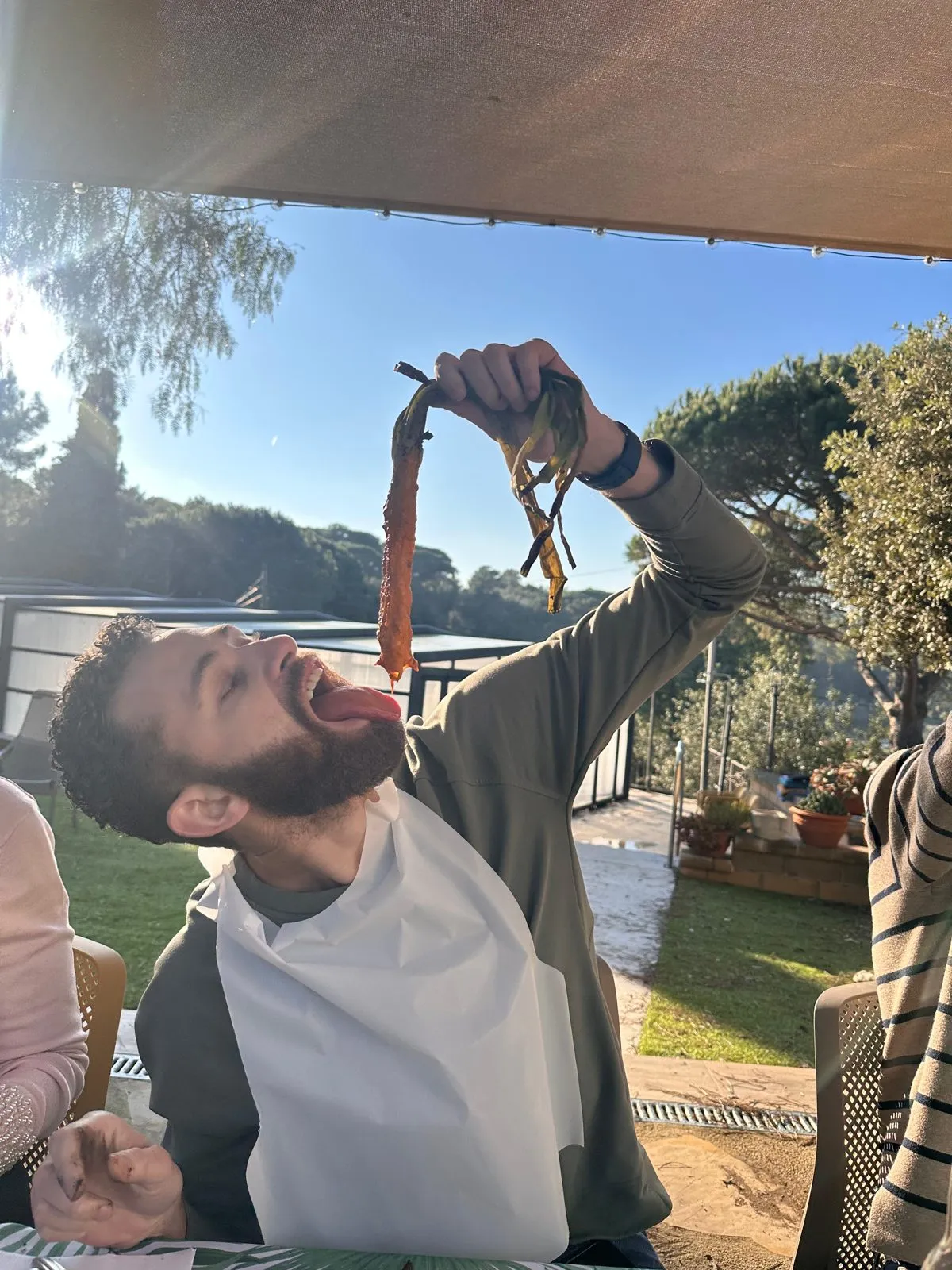 Un comensal con babero comiéndose un calçot