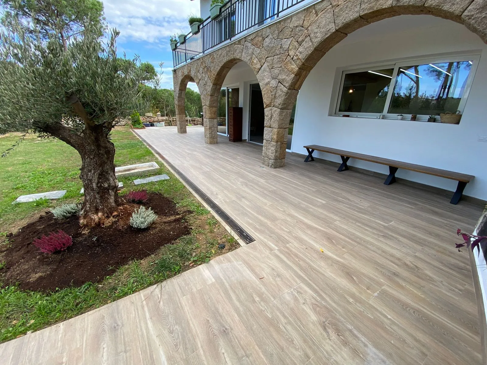 Porche con arcadas de piedra y olivo junto a la terraza