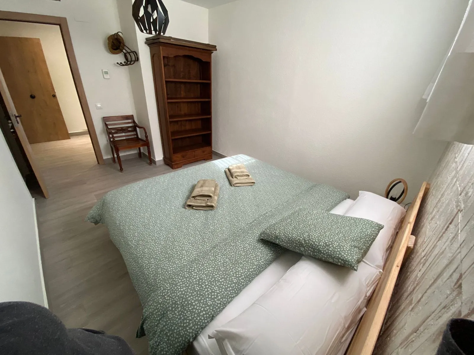 Dormitorio con cama doble y ropa de cama verde