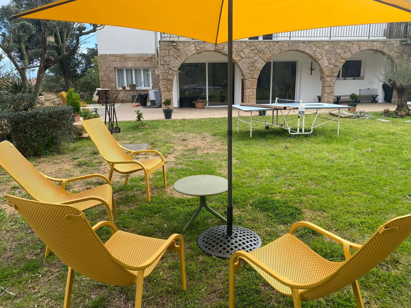 Jardín con tumbonas, sombrilla y mesa de ping-pong