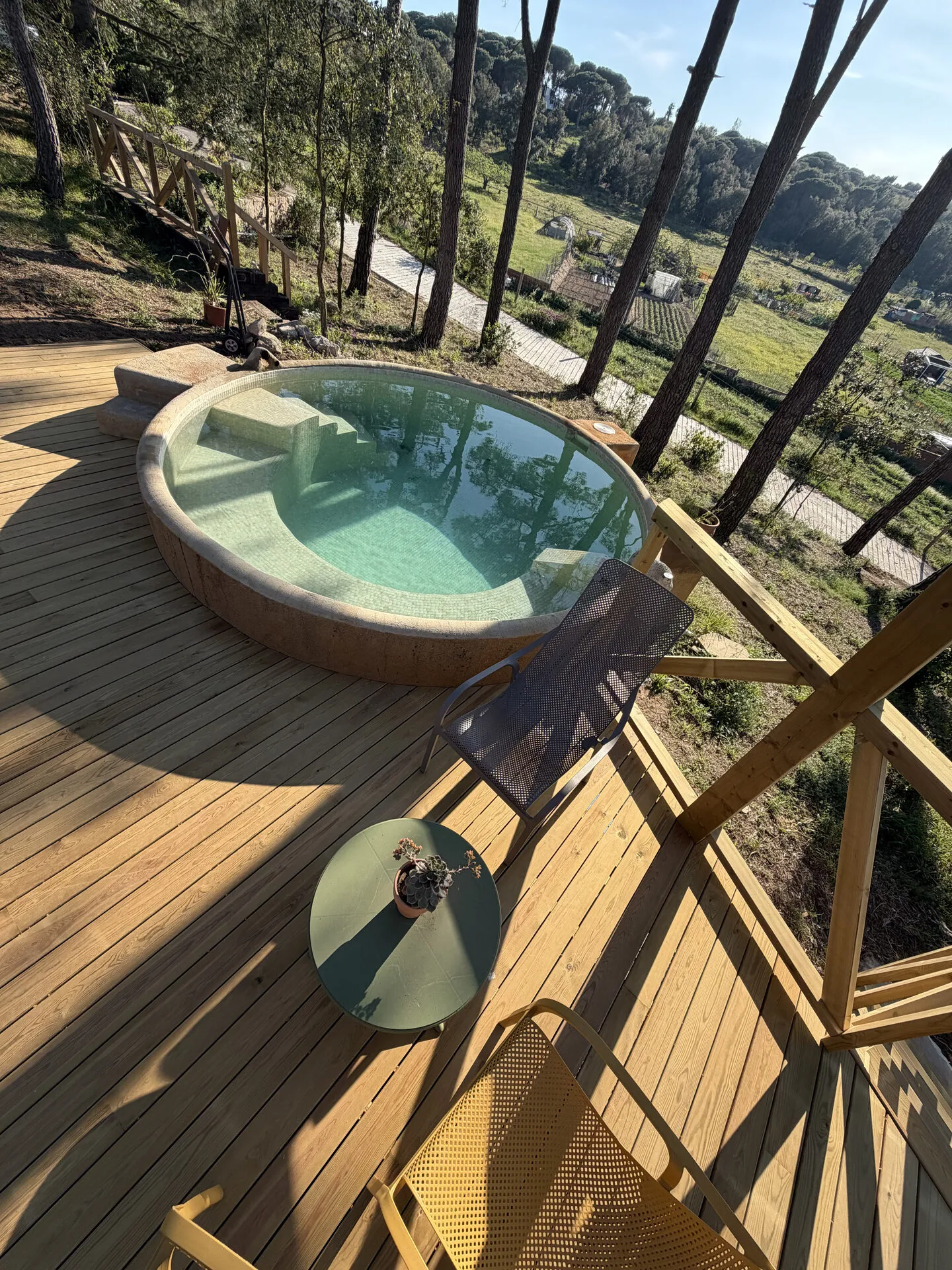 La piscina redonda con sus escalones de obra, vista desde la tarima