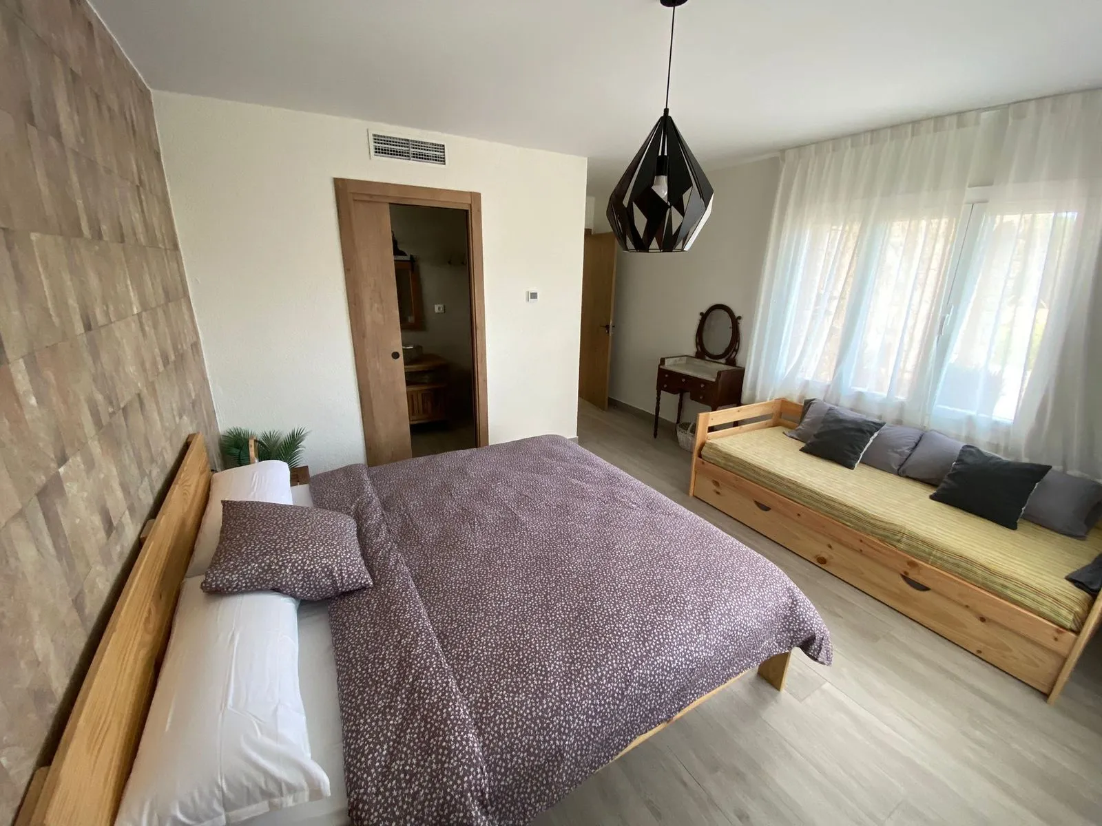 Dormitorio suite con cama doble, sofá cama y baño propio