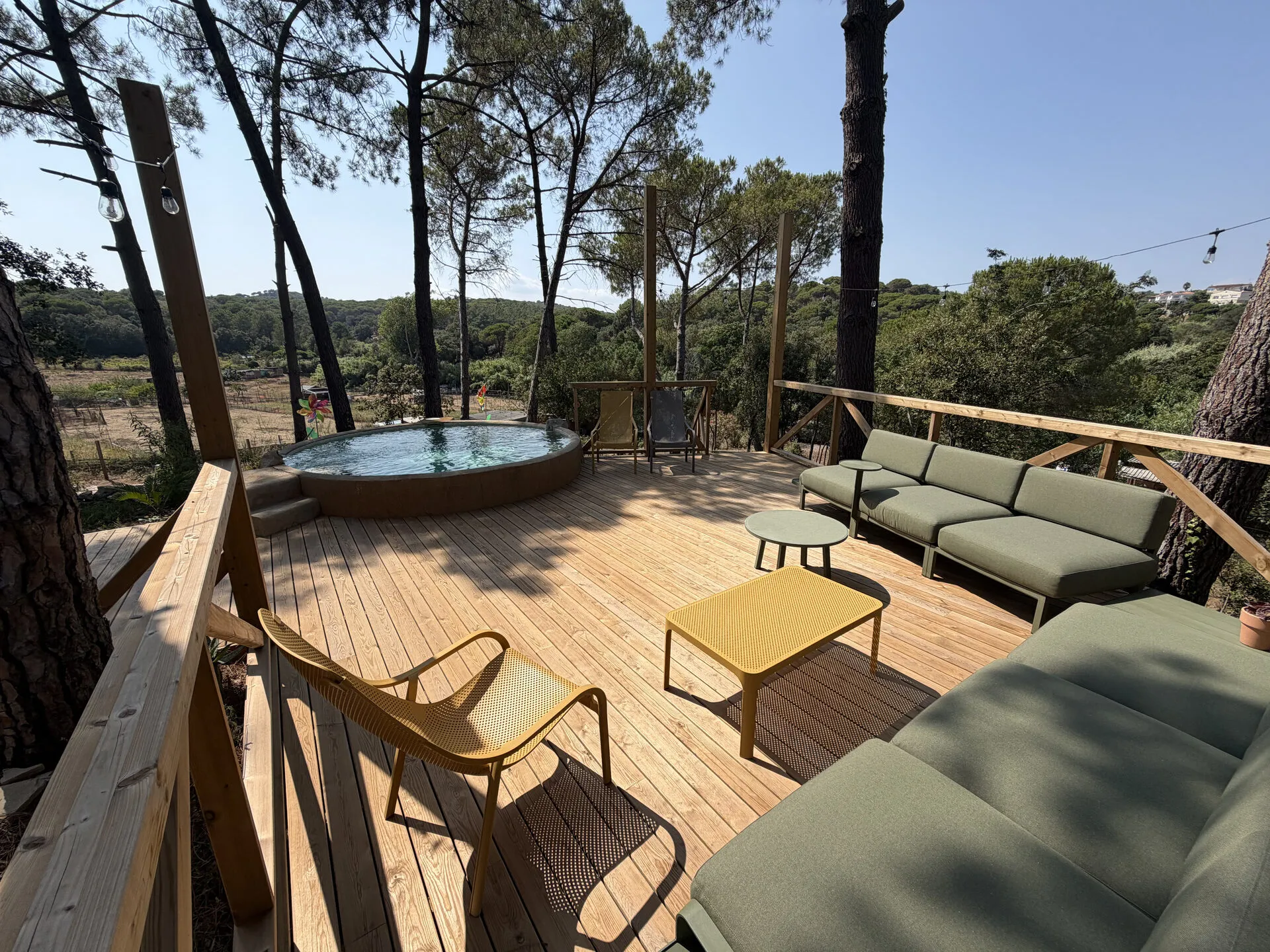 Los sofás del chillout en la tarima de madera, junto a la piscina